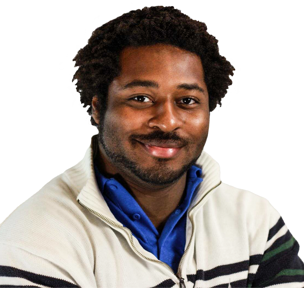 Smiling man with curly hair wearing a white zip-up sweater over a blue collared shirt against a plain background.