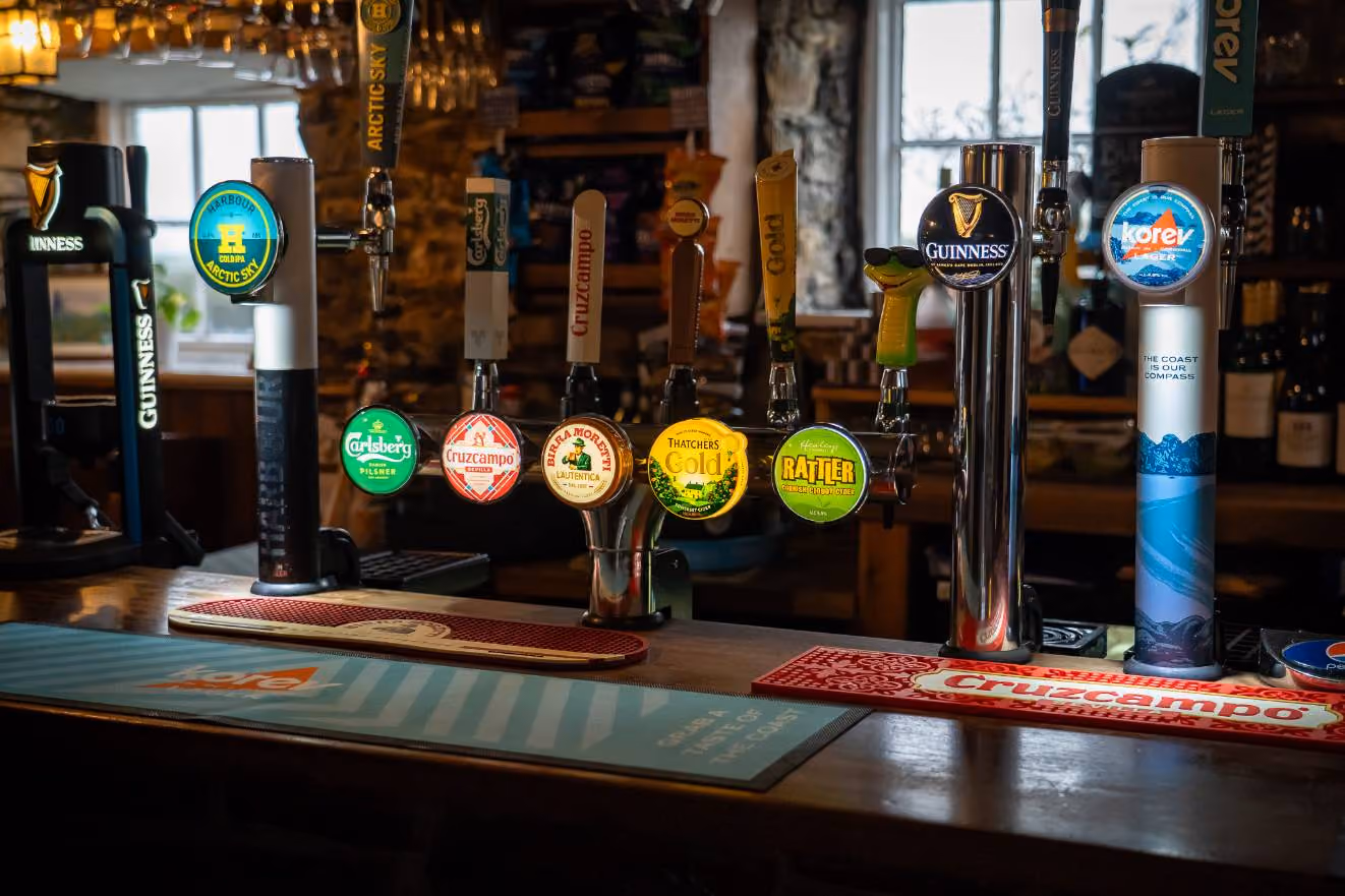 Bar beer taps with labels including Guinness, Carlsberg, Cruzcampo, Moretti, Thatchers Gold, Rattler, and Korev.