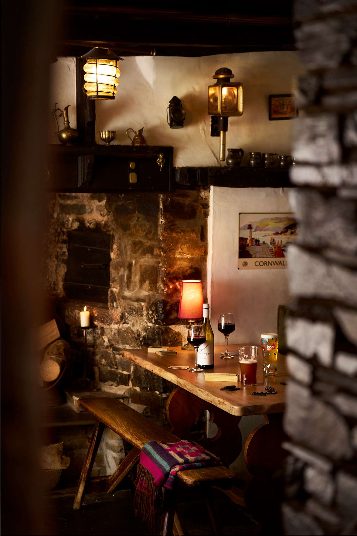 A pint of Guinness stout with foam head on a wooden table with a warm blurred background.