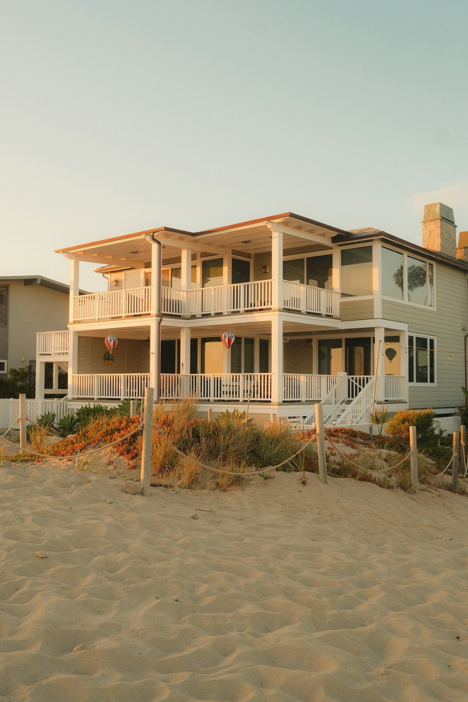 Beach house overlooking sandy dunes at sunset