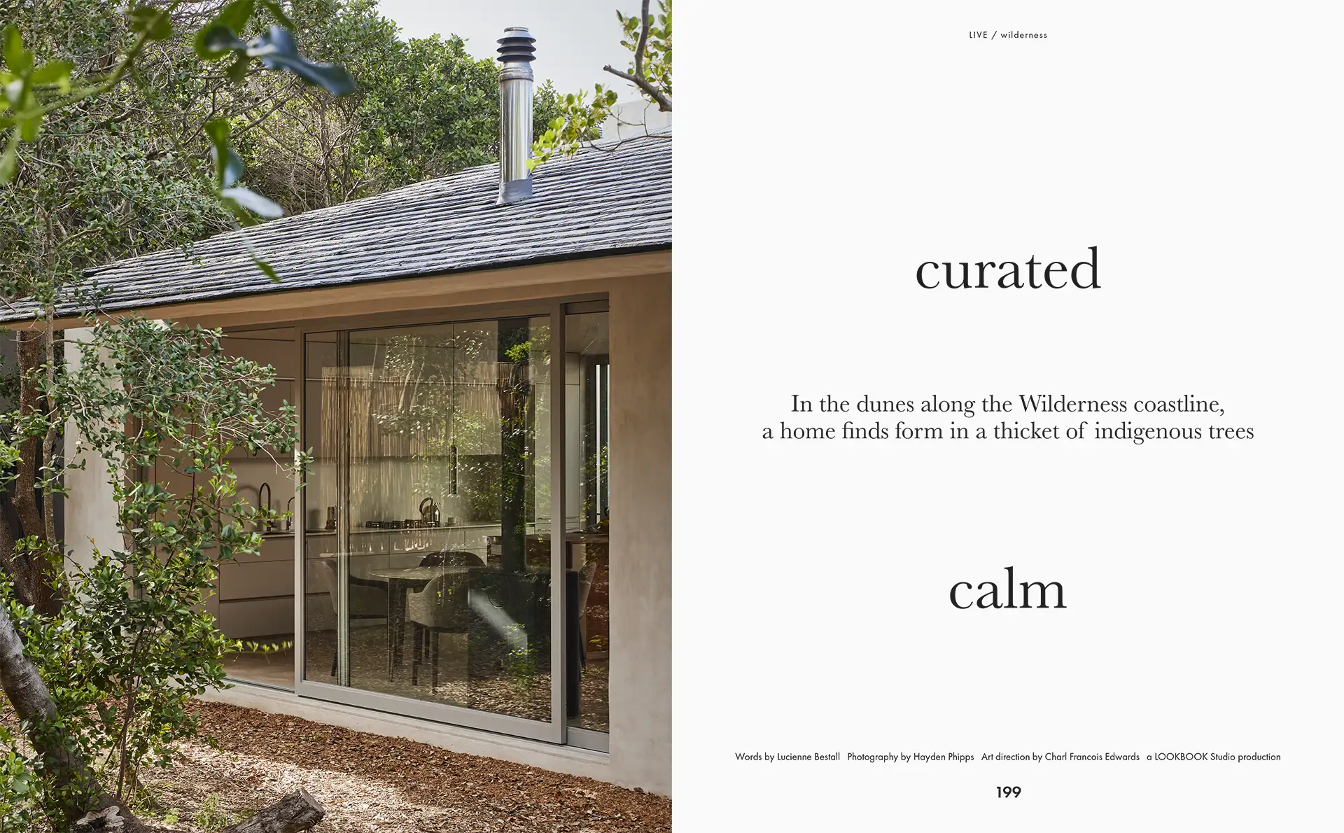 Modern home with floor-to-ceiling glass doors nestled in dense indigenous trees on a wilderness coastline.