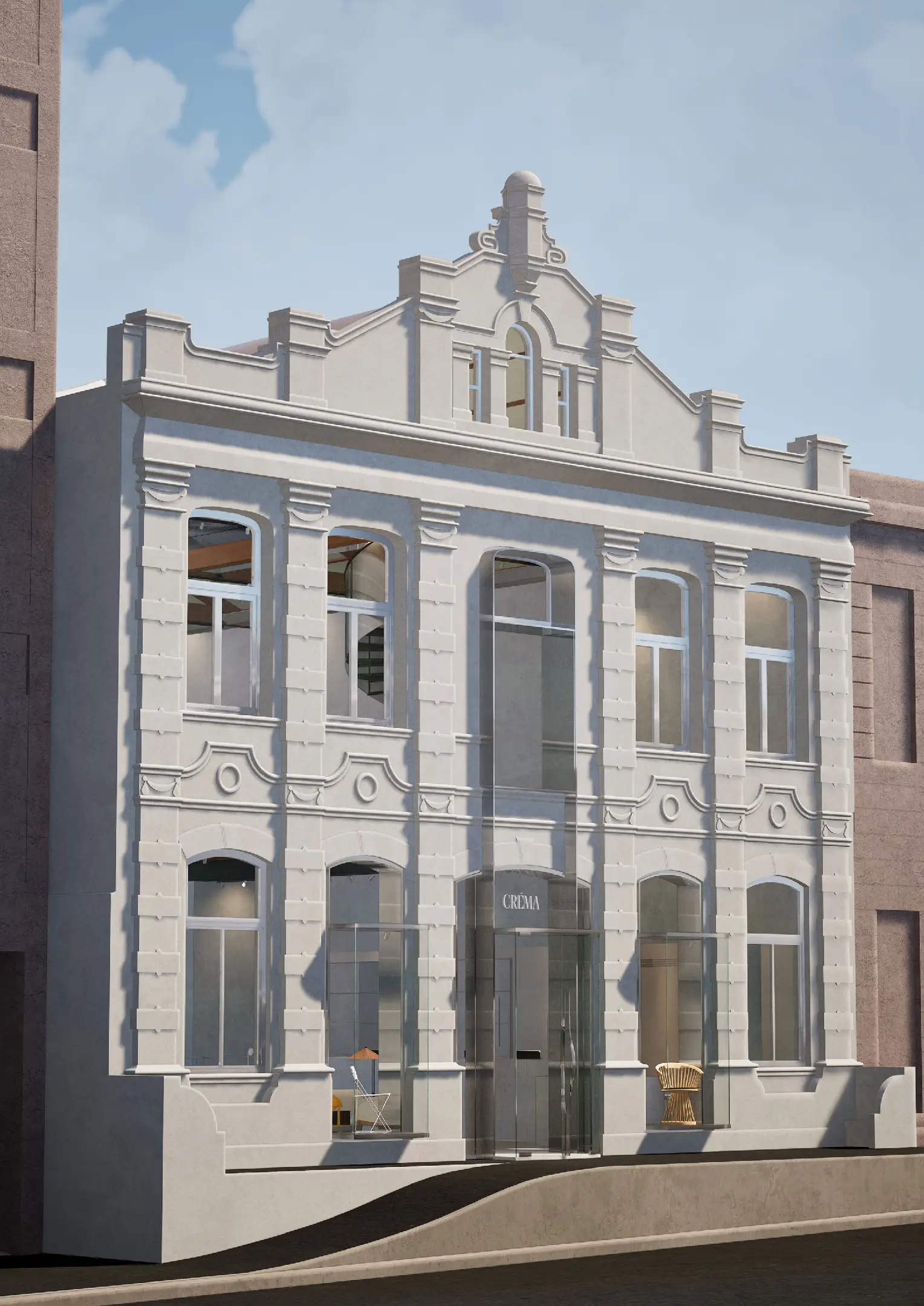 Historic two-story cream building with ornate details and glass entrance displaying 'CRÈMA' sign.