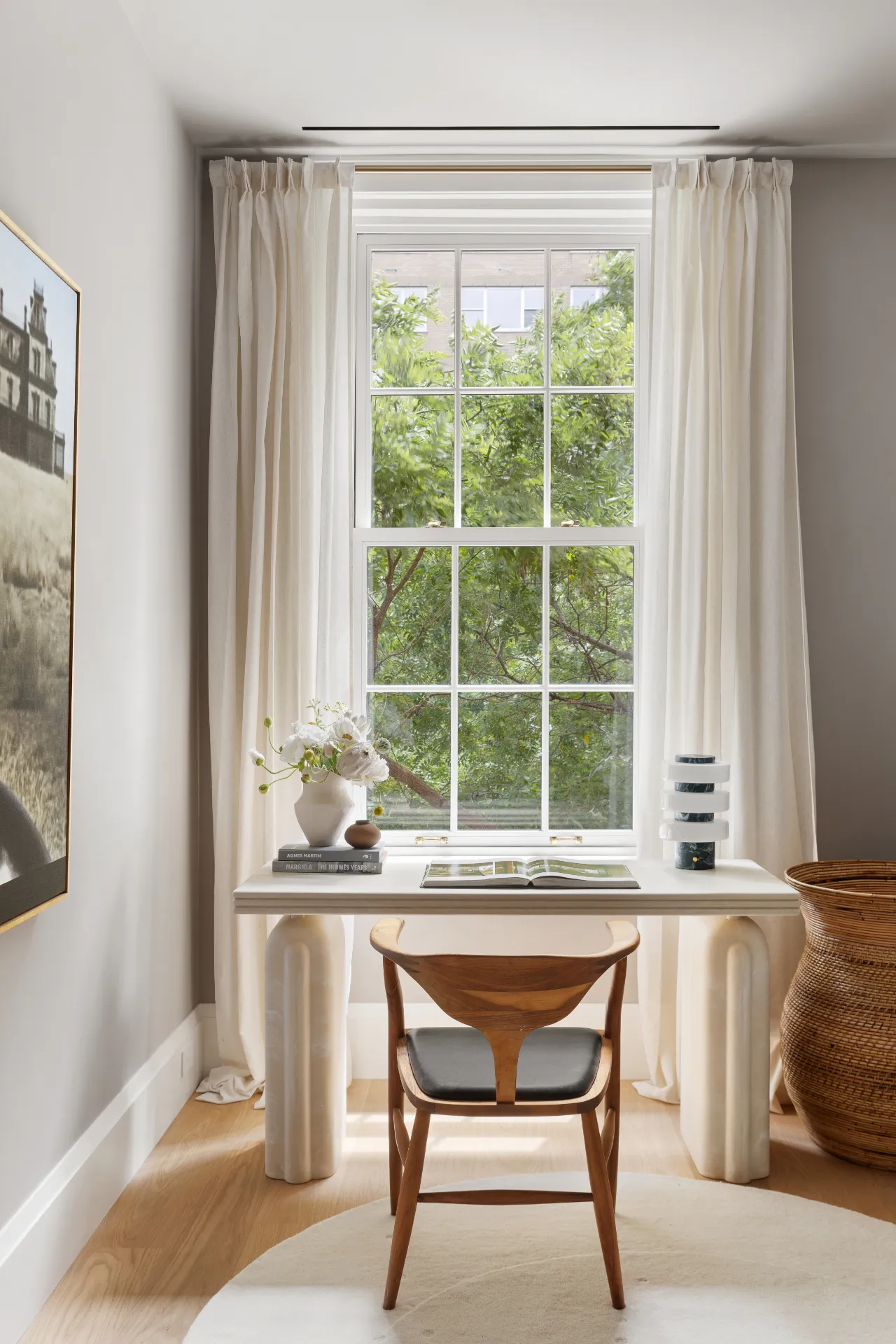 small desk in front of a window looking out onto green trees
