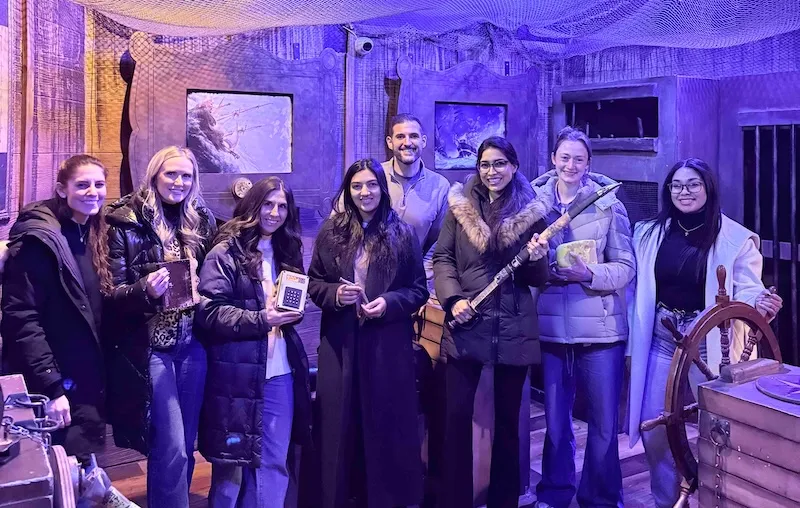 Group of people dining and smiling together at a warm, cozy restaurant table.