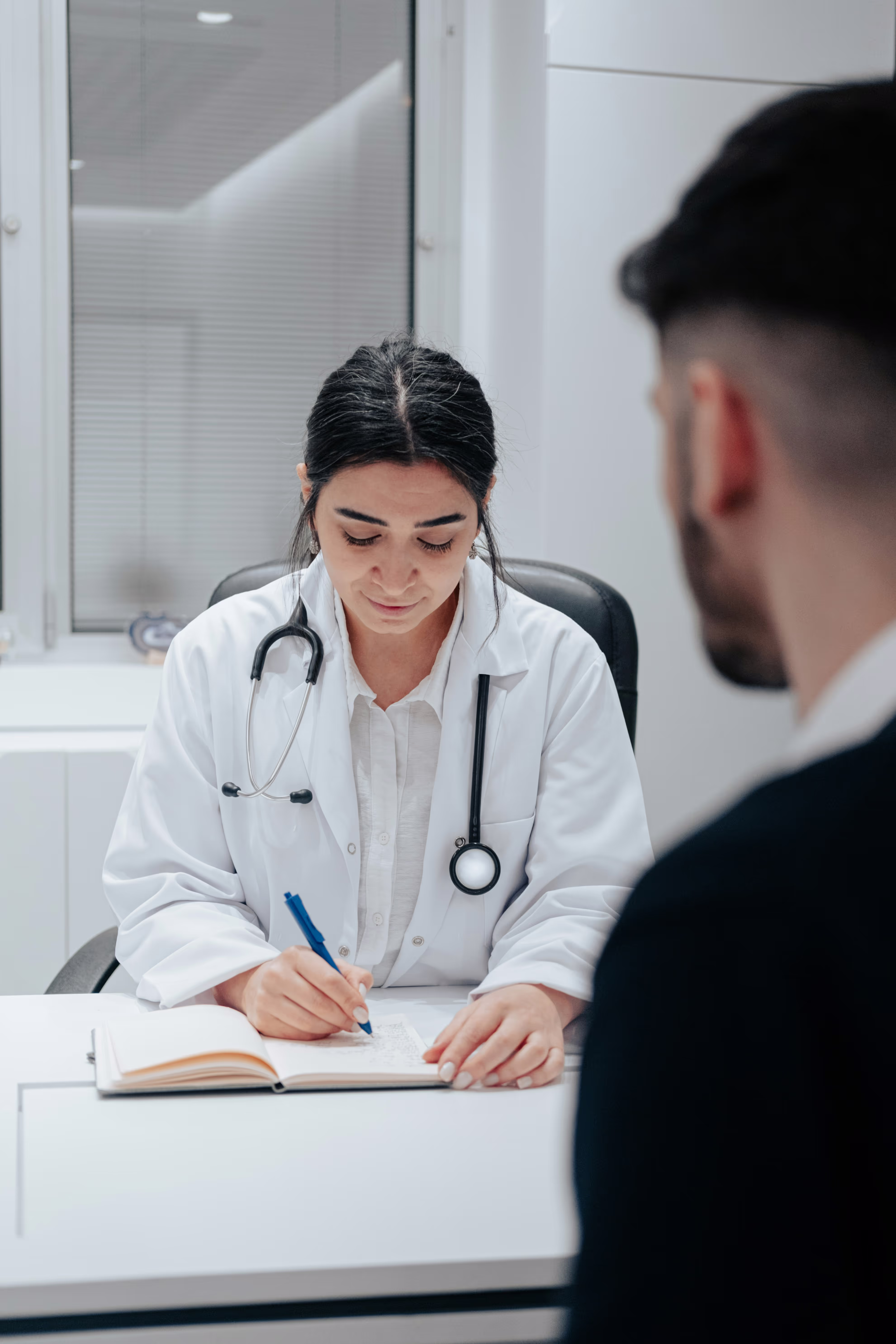 Consultation médicale pour l'alopécie. Un médecin spécialisé discute avec un patient de sa prise en charge.