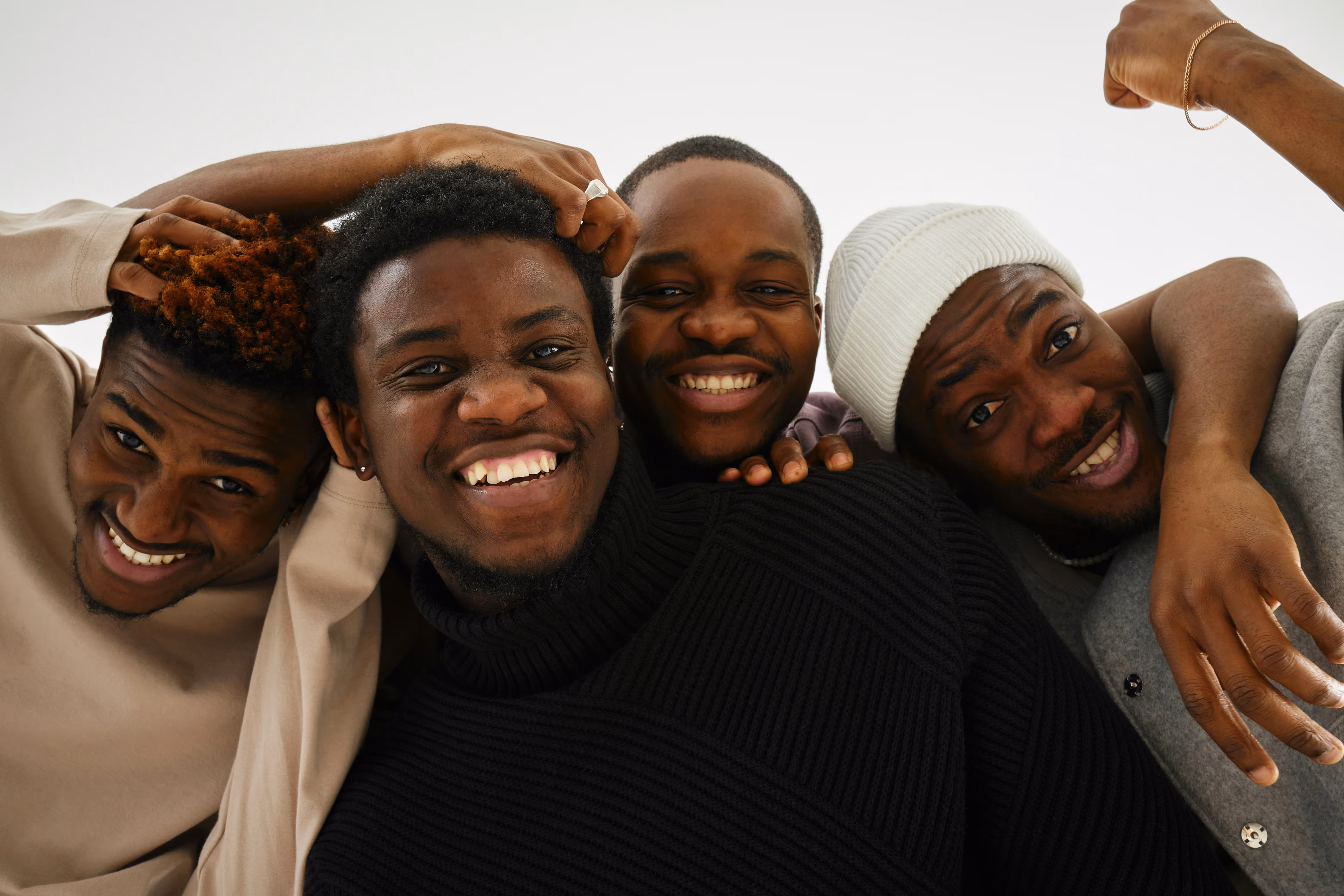 Groupe de jeunes hommes aux cheveux variés, illustrant les options et l'accompagnement pour l'alopécie.