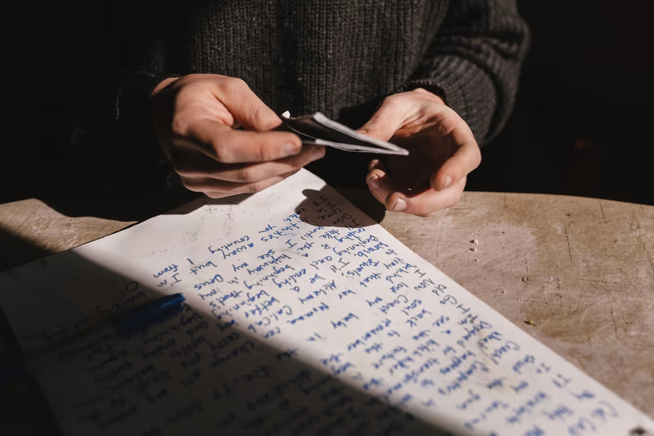 Mains manipulant des cartes au-dessus d'un document, illustrant les démarches personnalisées pour la prise en charge de l'alopécie.