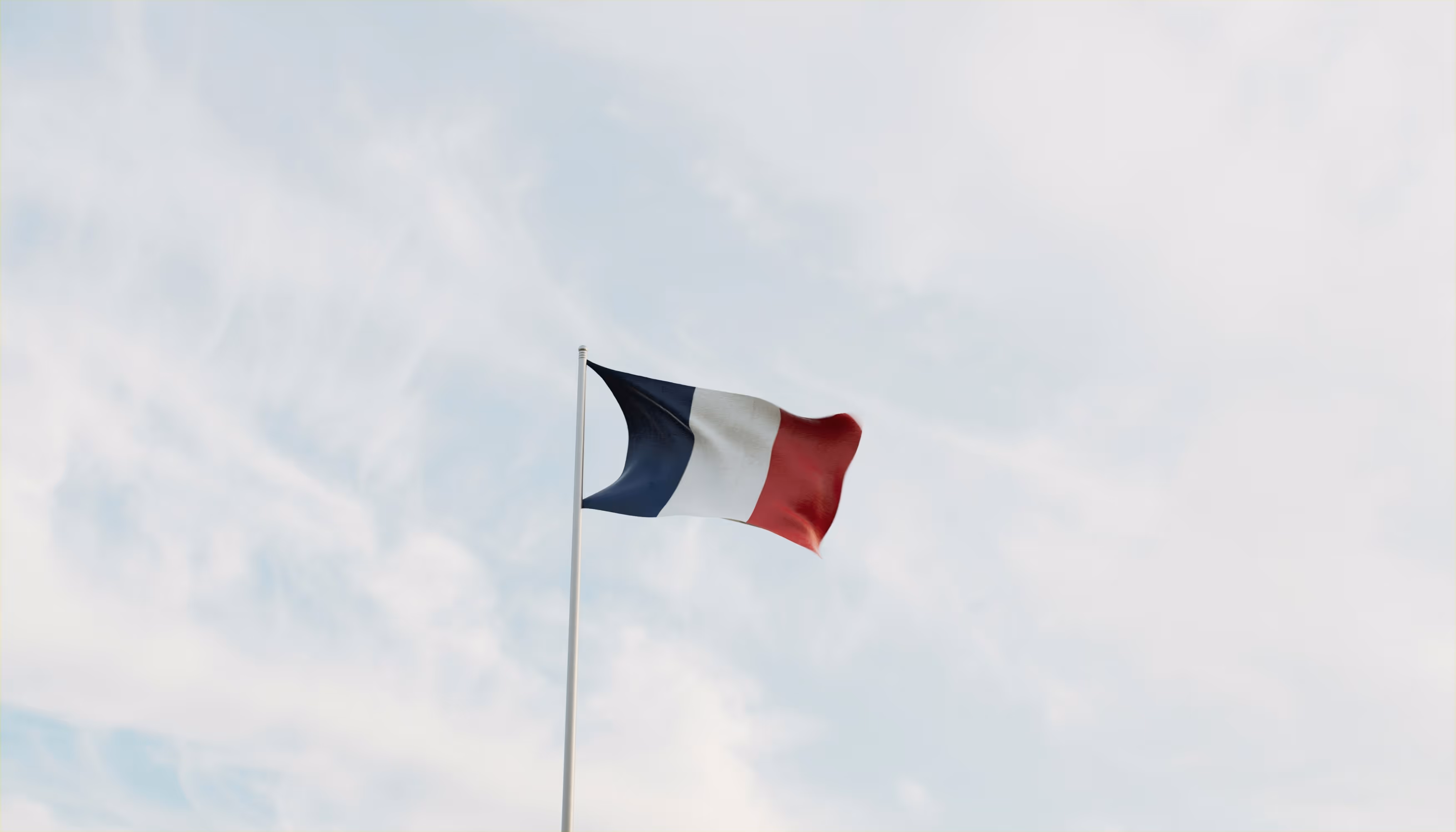 Drapeau français flottant dans le ciel, symbolisant l'expertise en prise en charge de l'alopécie disponible en France.