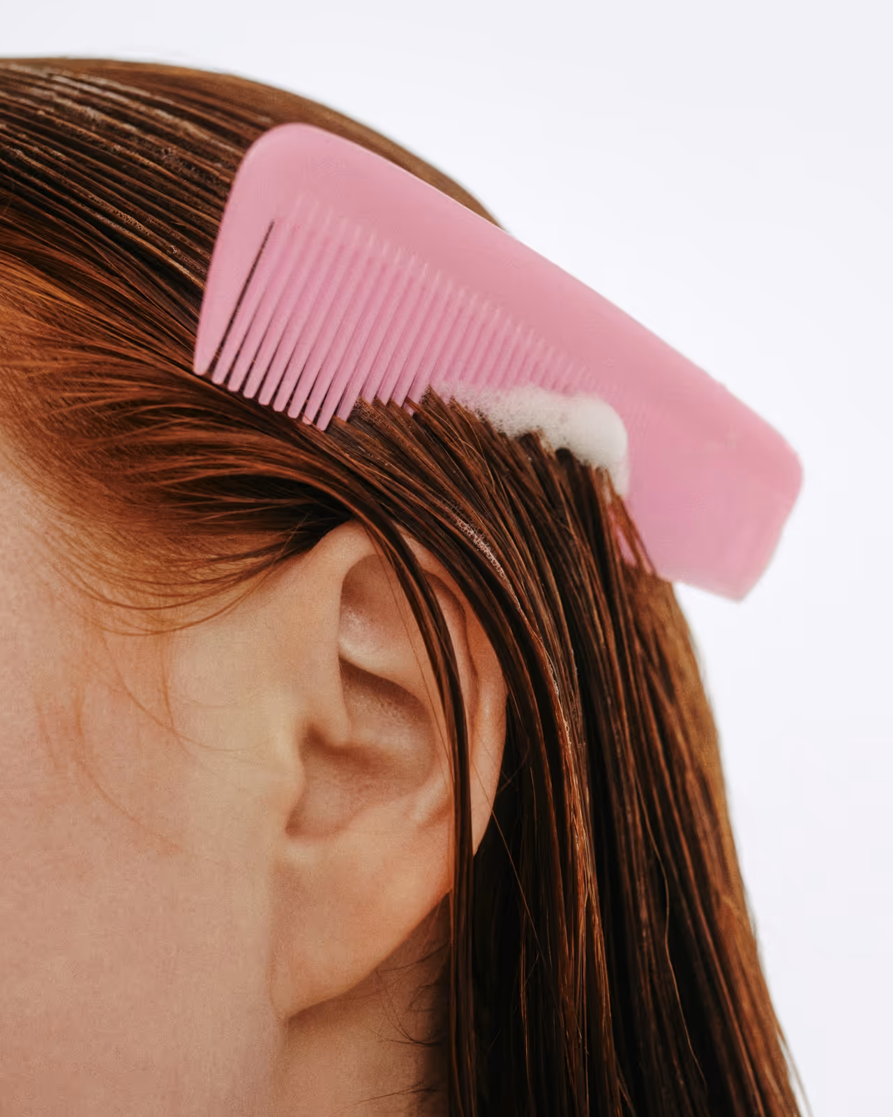 Application de produit capillaire pour l'alopécie, avec une mousse et un peigne sur cheveux humides. Soin cheveux efficace.