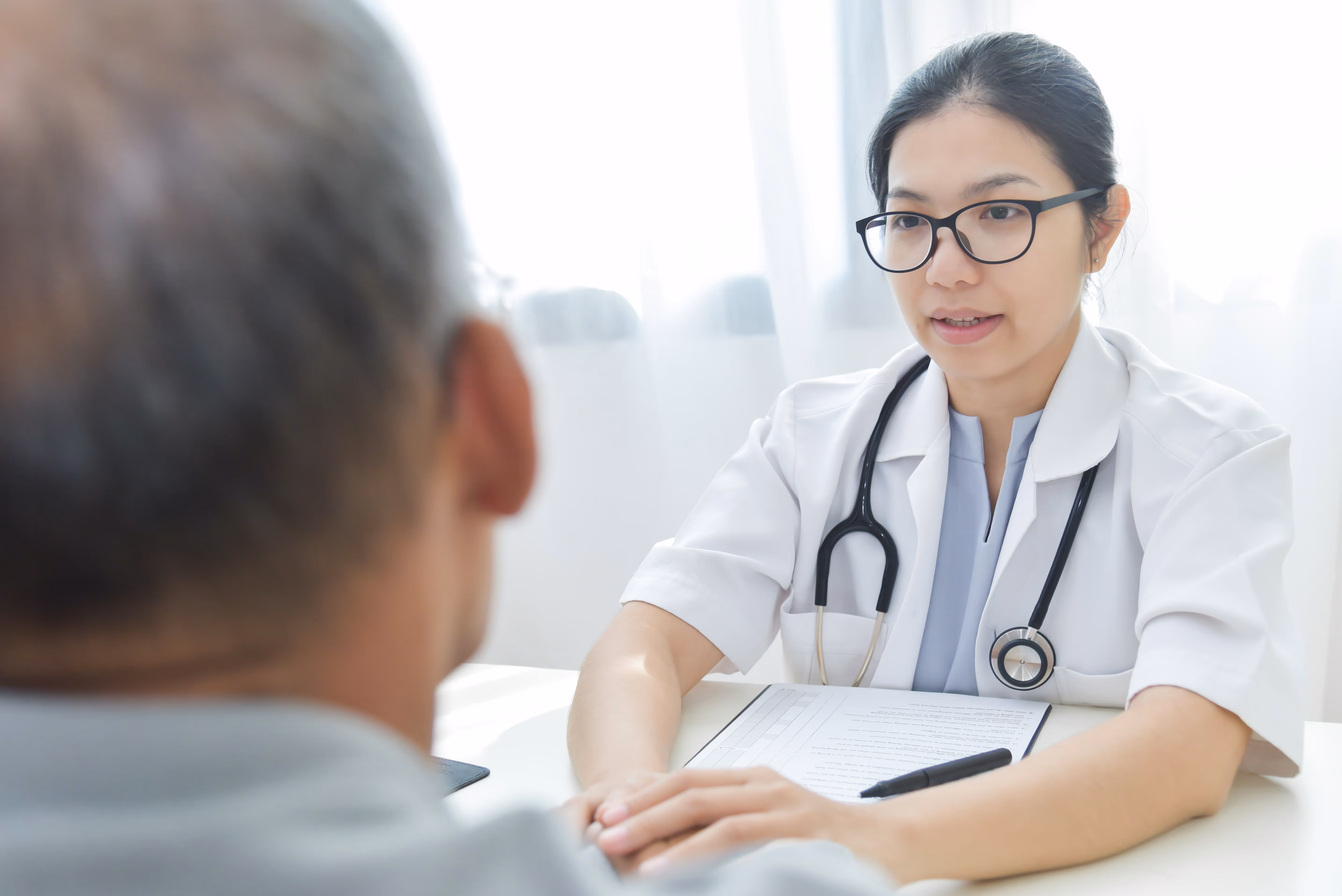 Consultation médicale pour l'alopécie en France. Médecin expliquant les options de prise en charge à un patient.