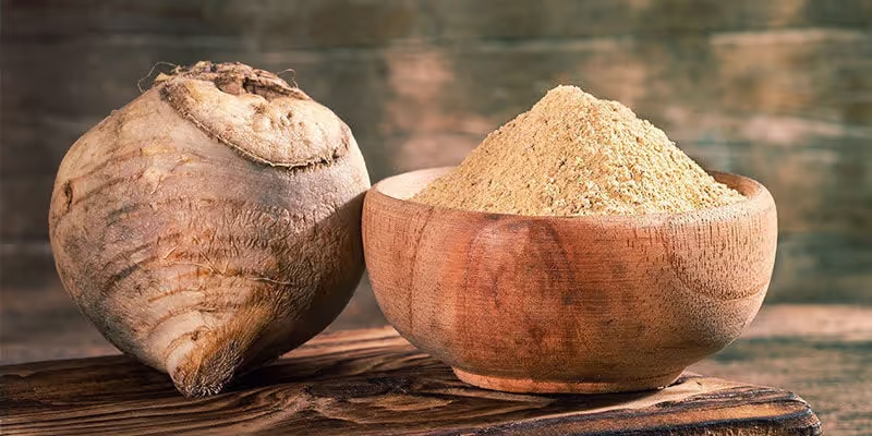 Racine de maca et poudre de maca dans un bol en bois, solutions naturelles pour la gestion de l'alopécie en France.