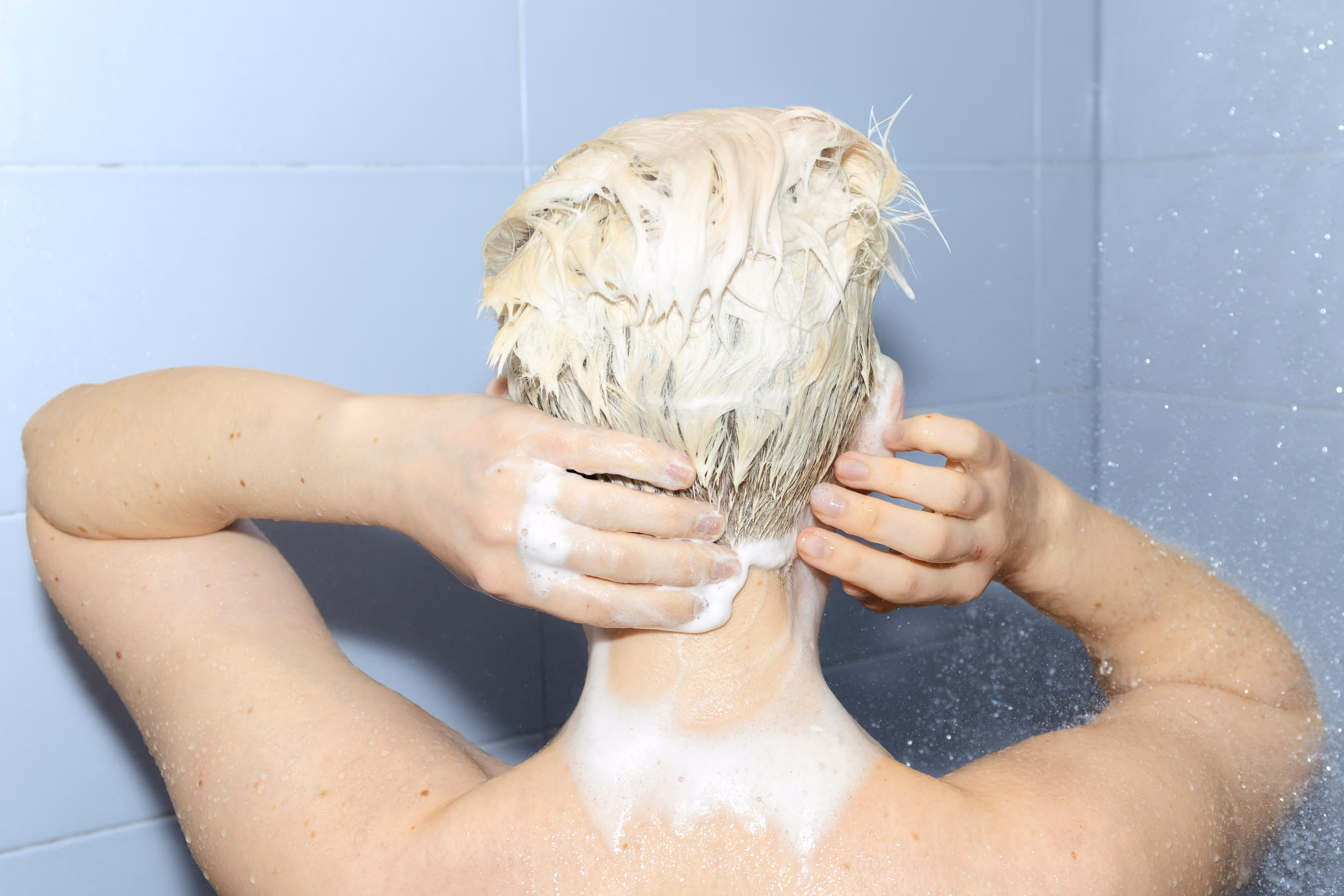 Lavage cheveux blonds courts avec shampoing dans la douche pour cuir chevelu sensible, routine soin capillaire alopecie