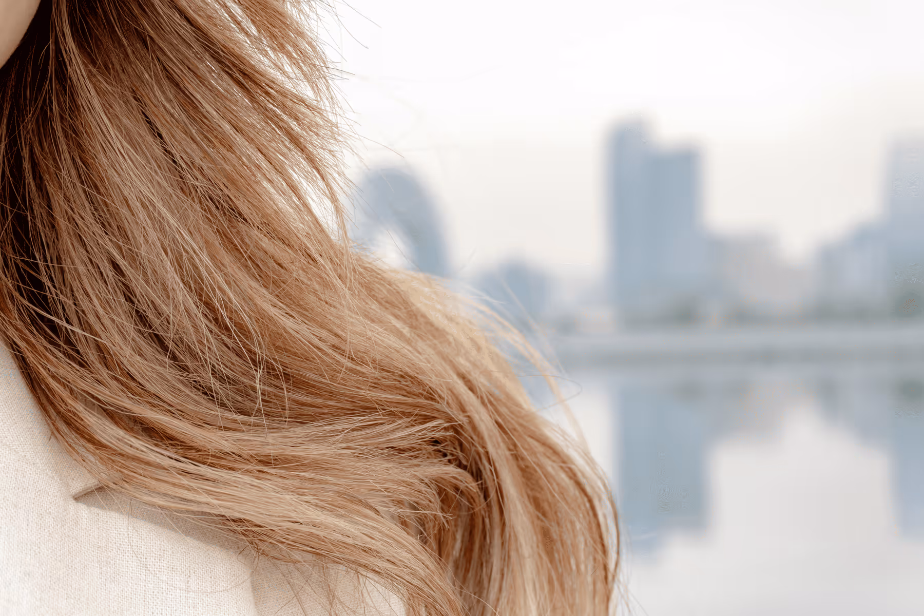 Cheveux châtains clairs d'une femme, évoquant le volume et la vitalité. Solutions pour l'alopécie et la santé capillaire.