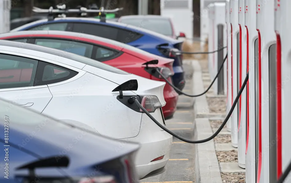 Tesla Elektroautos hintereinander an Ladesäulen angeschlossen
