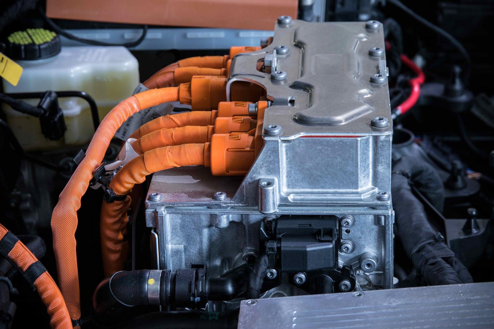 Side view of electric vehicle power train with huge power suply cables in orange insulation.