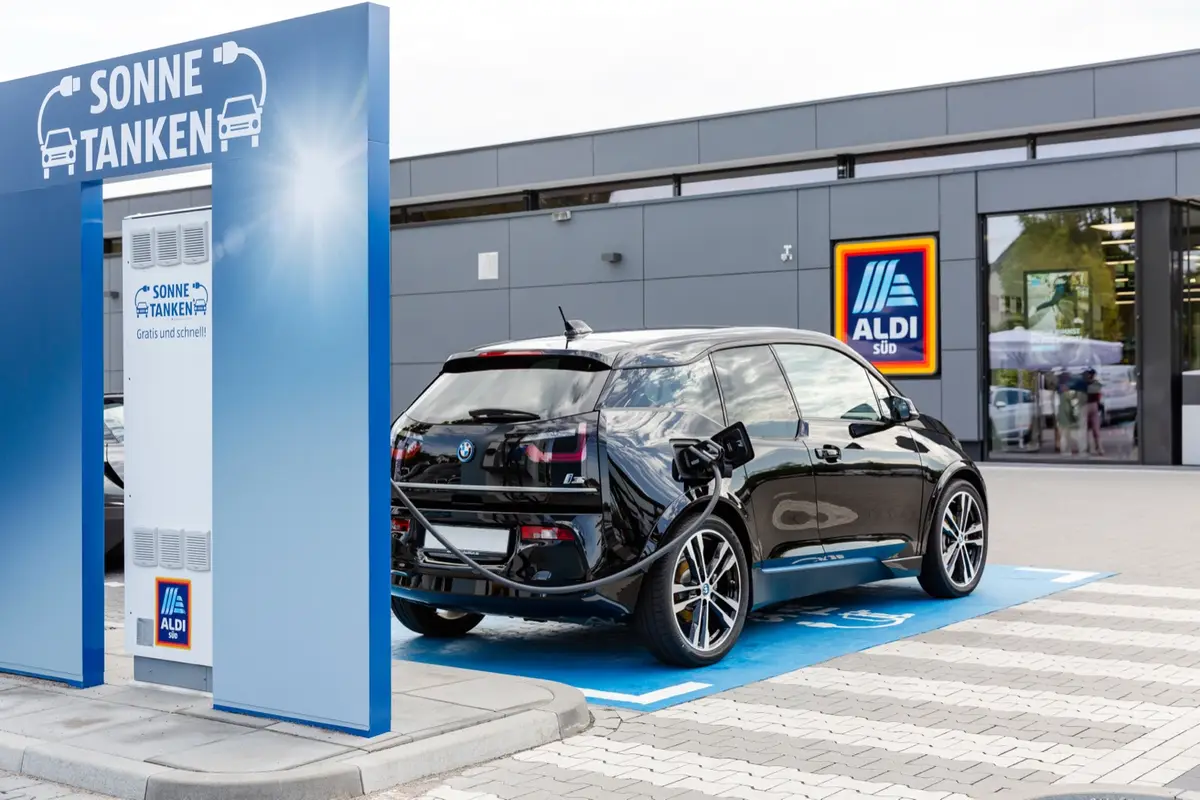 Schwarzer BMW i3 an einer ALDI-SÜD-Ladesäule vor einem Markt.