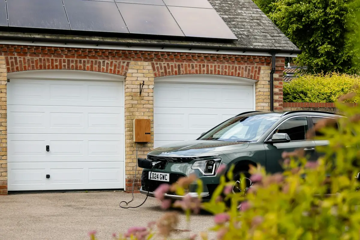 ein KIA EV beim laden an einer Garage mit Photovoltaik