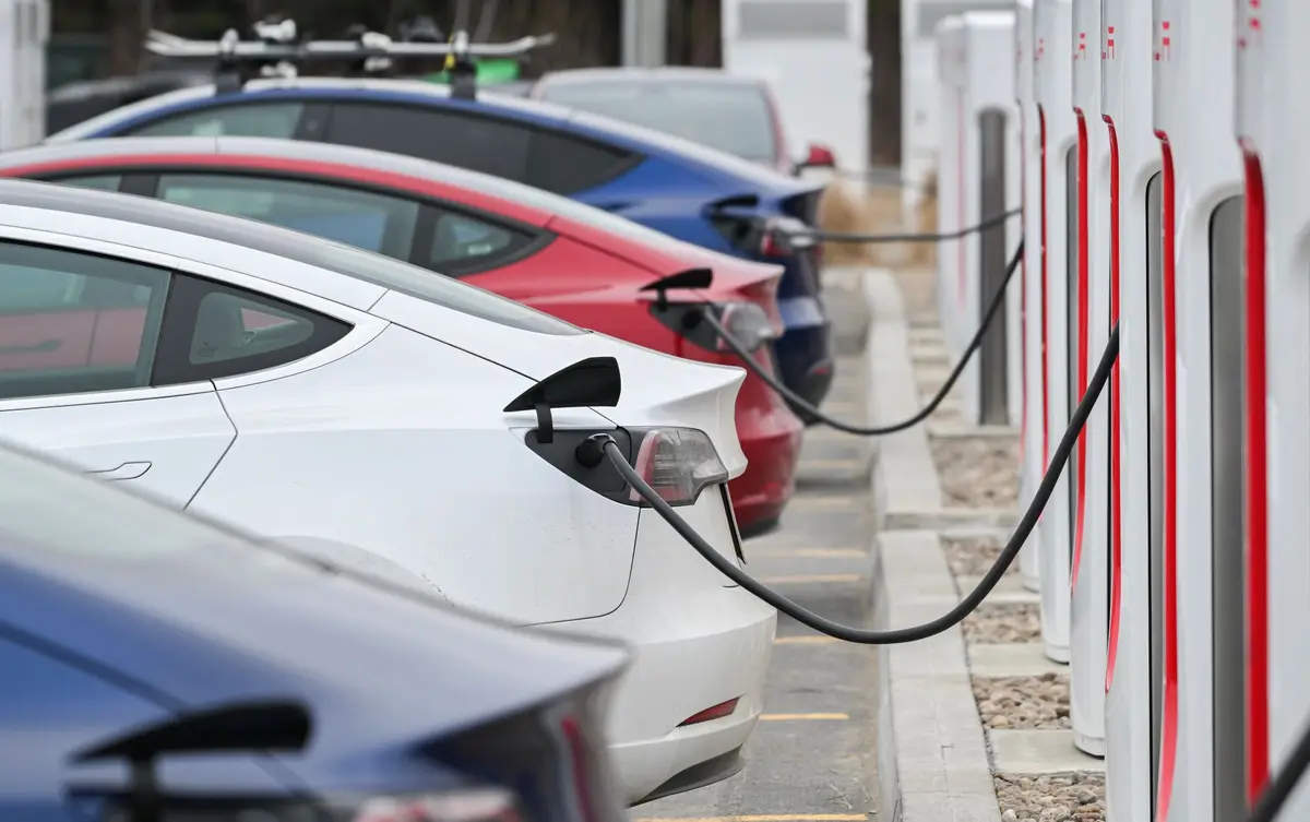 Eine Reihe von Tesla Model 3 an Superchargern