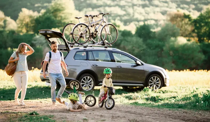 Eine Familie vor einem großen elektrischen Auto