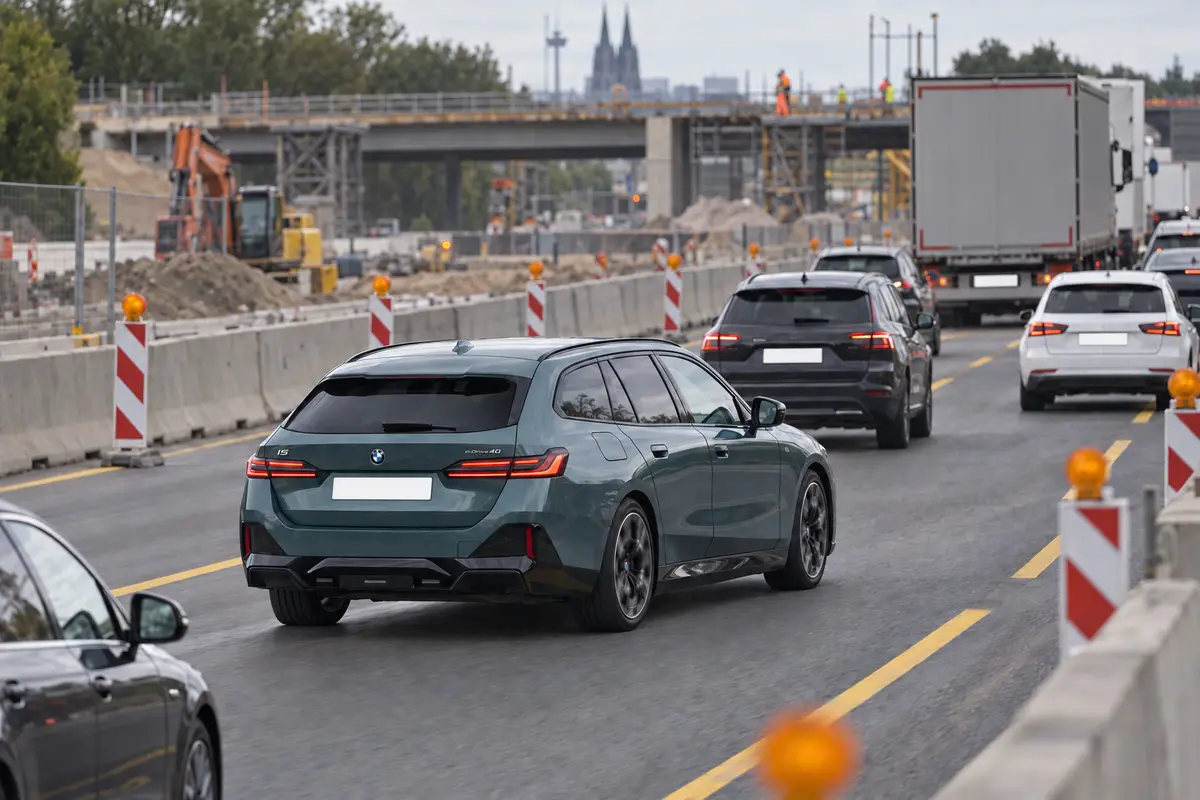 BMW i5 Touring fährt im dichten Verkehr einer Autobahnbaustelle, KI-generiert