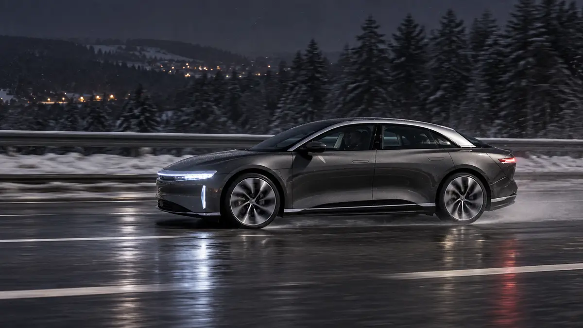 Ein Lucid Air Grand Touring fährt nachts dynamisch über eine winterliche Autobahn. KI-generiert.