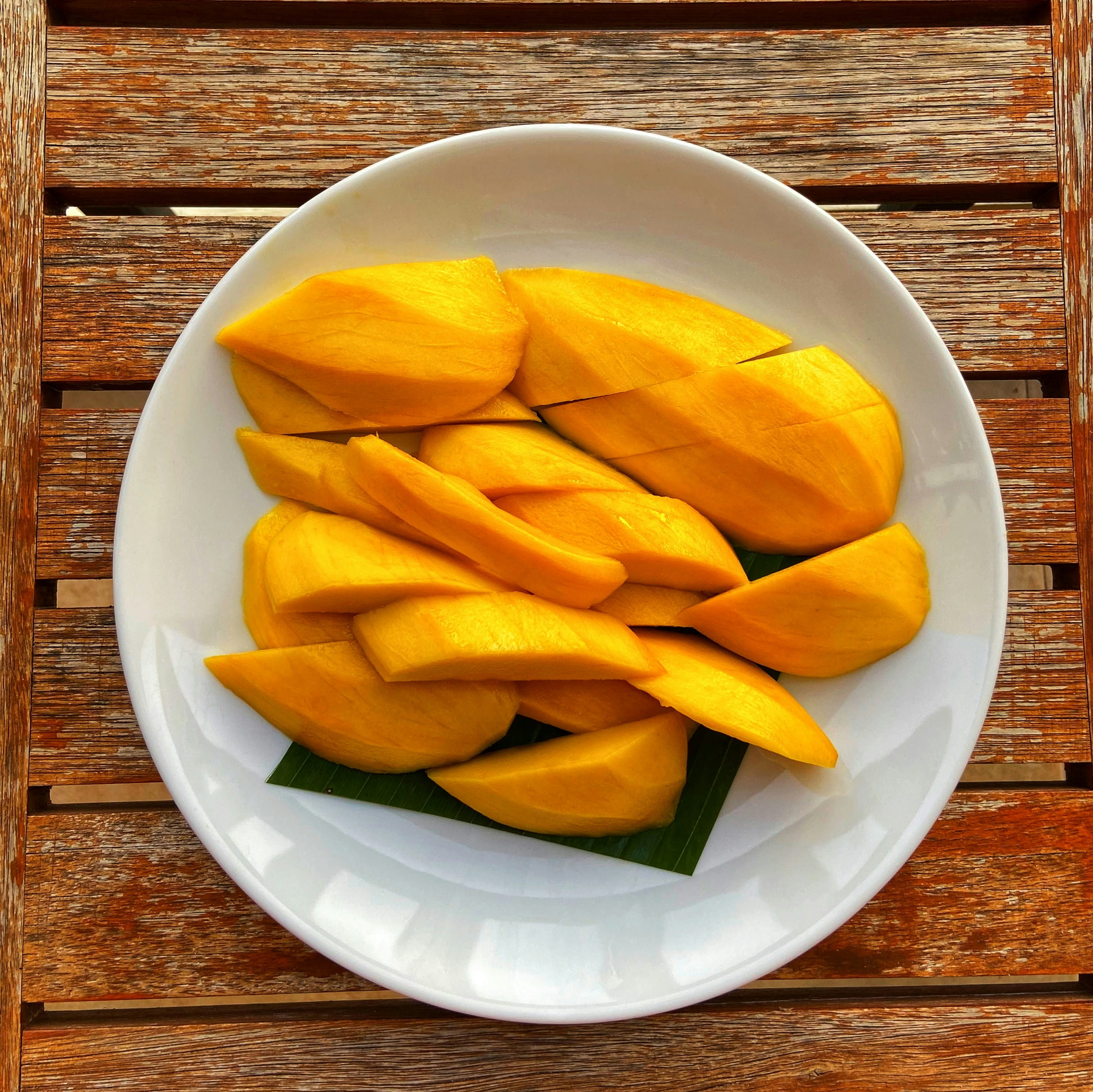 plate of mango slices on wood table