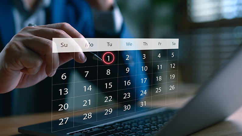 Businessman scheduling a digital calendar on laptop, highlighting the first of the month, symbolizing time management, appointment booking, event planning, productivity, and smart scheduling system.