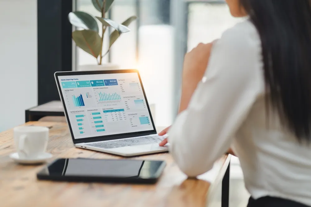 Professional data analyst using data visualizations dashboard on computer monitor