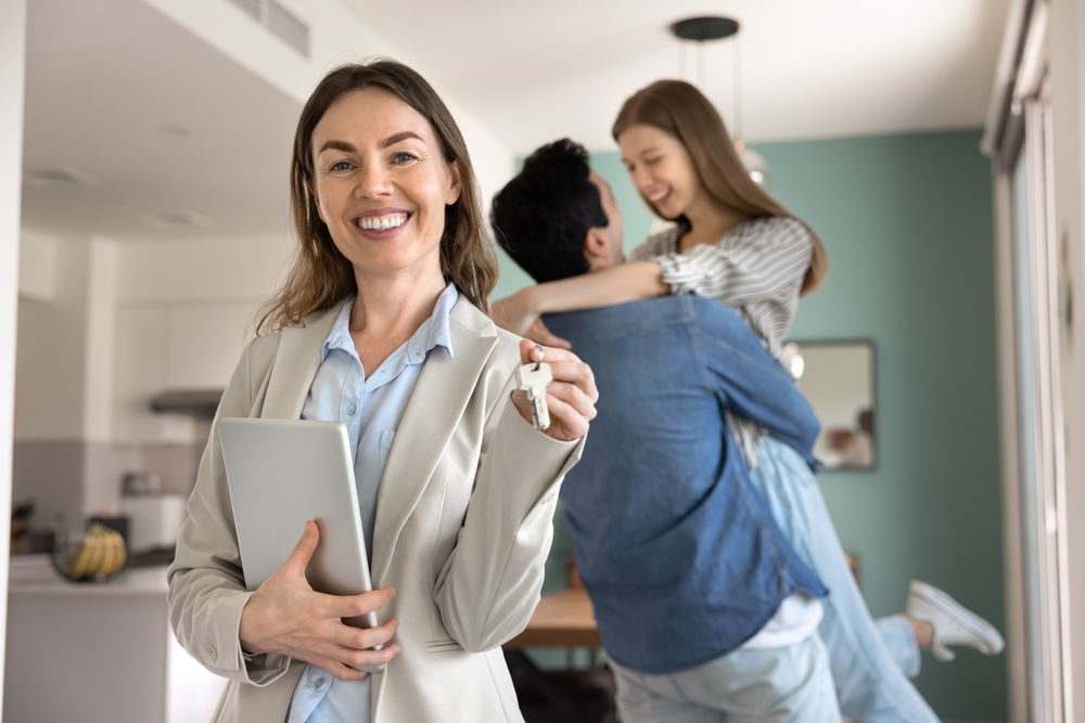 ortrait of young professional real estate agent holding tablet and keys
