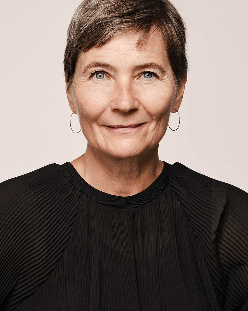 A professional studio portrait of Lene Dammand Lund, Rector of the Royal Danish Academy, wearing a black blouse against a neutral background.
