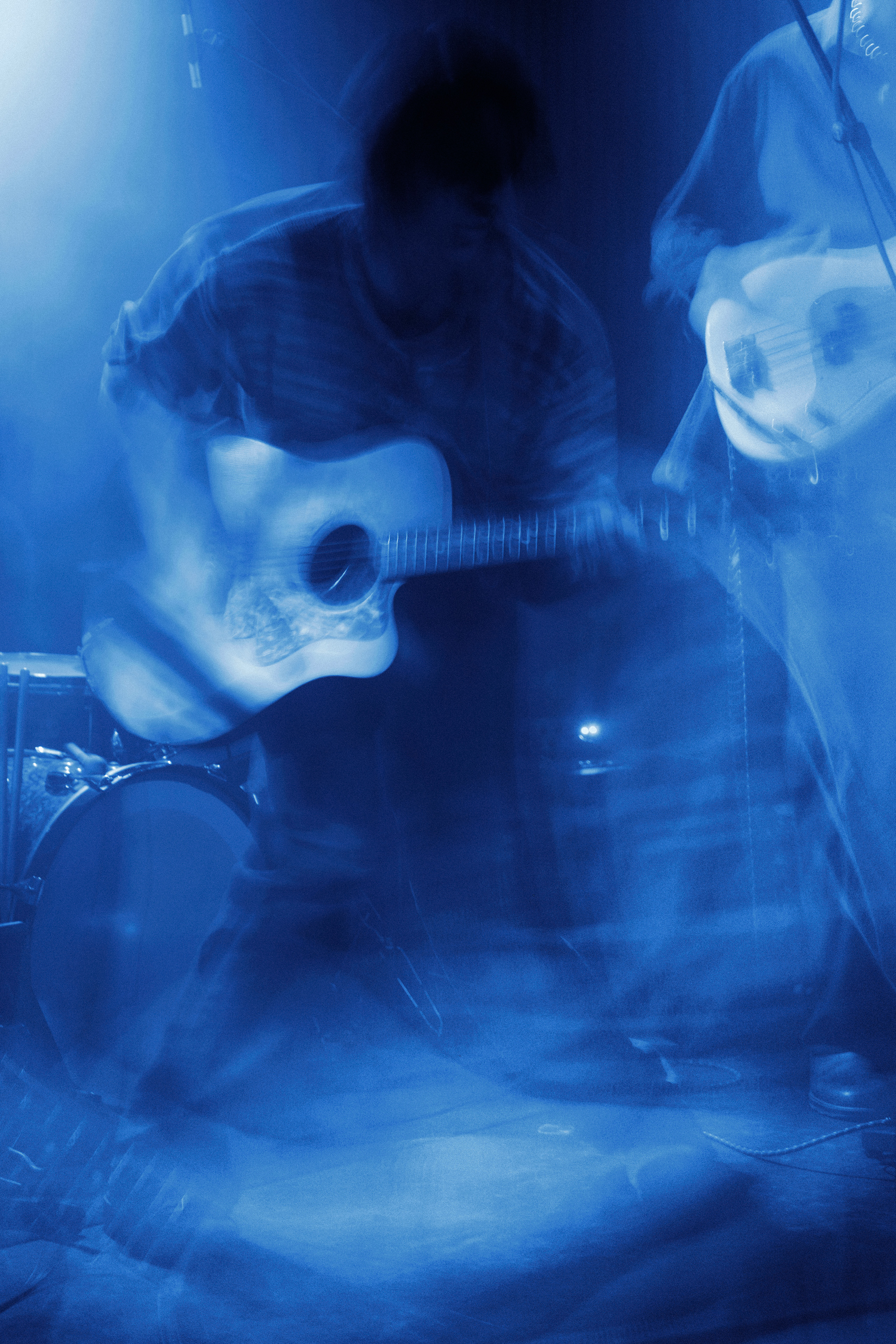 Thoughtfool vocalist singing and playing acoustic guitar during a live performance at Rust in Copenhagen.