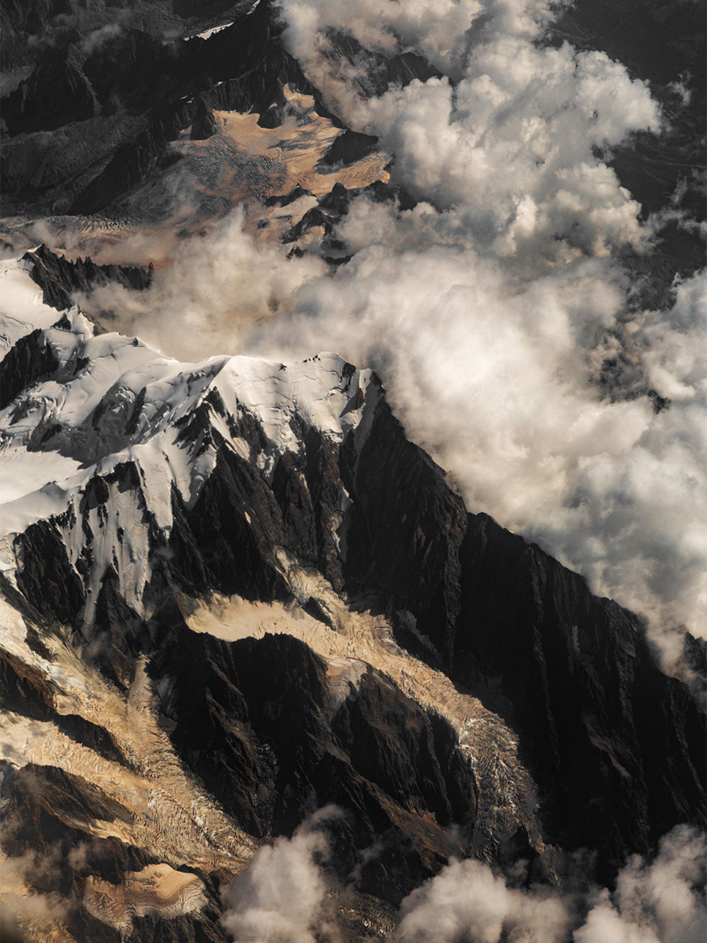 Aerial landscape photography of snow-covered peaks, glaciers and dramatic clouds in the European Alps by Patrick Pankalla.