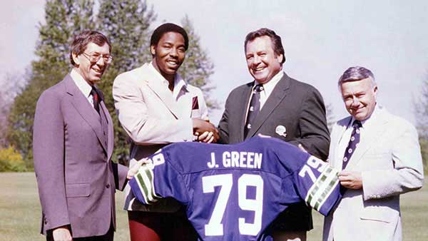 Jacob Green posing in front of his jersey, just drafted