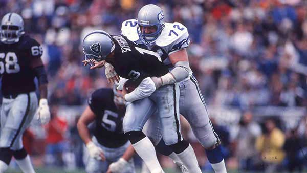 Joe Nash tackling a player on the field