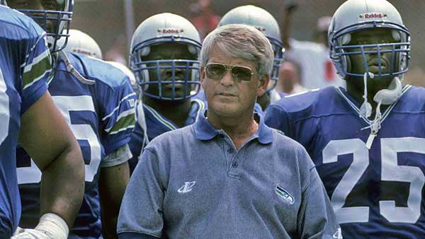 Picture of Dennis Erickson with Seahawks players in uniform around him
