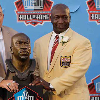 John Randle posing with his hall of fame bust 