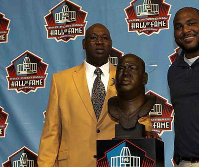 Cortez Kennedy posing in front of his Hall of Fame Statue