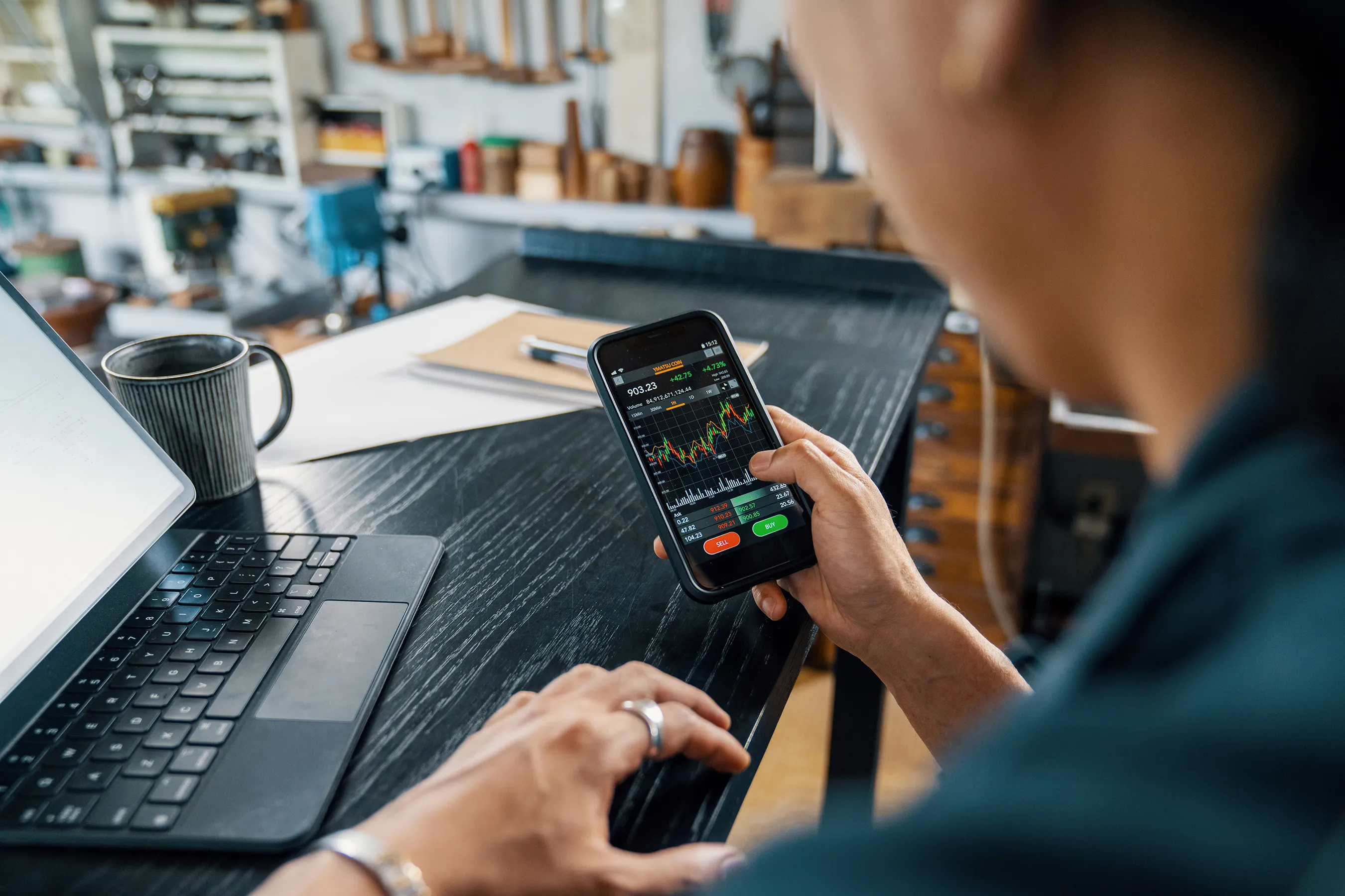 man looking at a trading chart on a phone - Forex Risk Management Tools