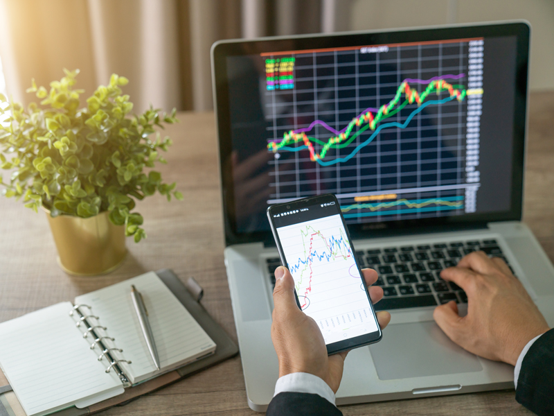 man holdiing a phone - Can You Make Money Day Trading