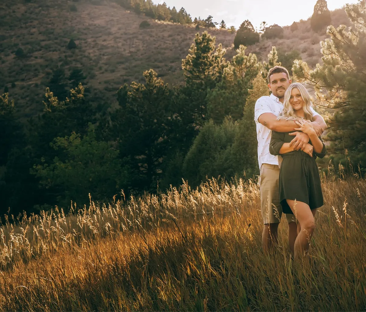 Couple embracing in golden field at sunset during Shutterpix Photography mountain session