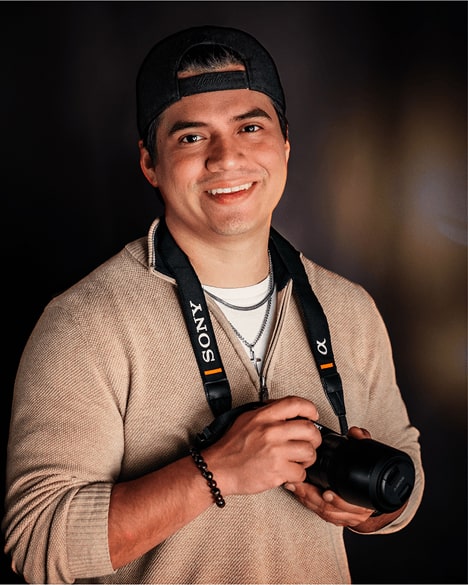 Brandon, Shutterpix photographer from Corpus Christi, TX, smiling with Sony camera in hand during studio portrait