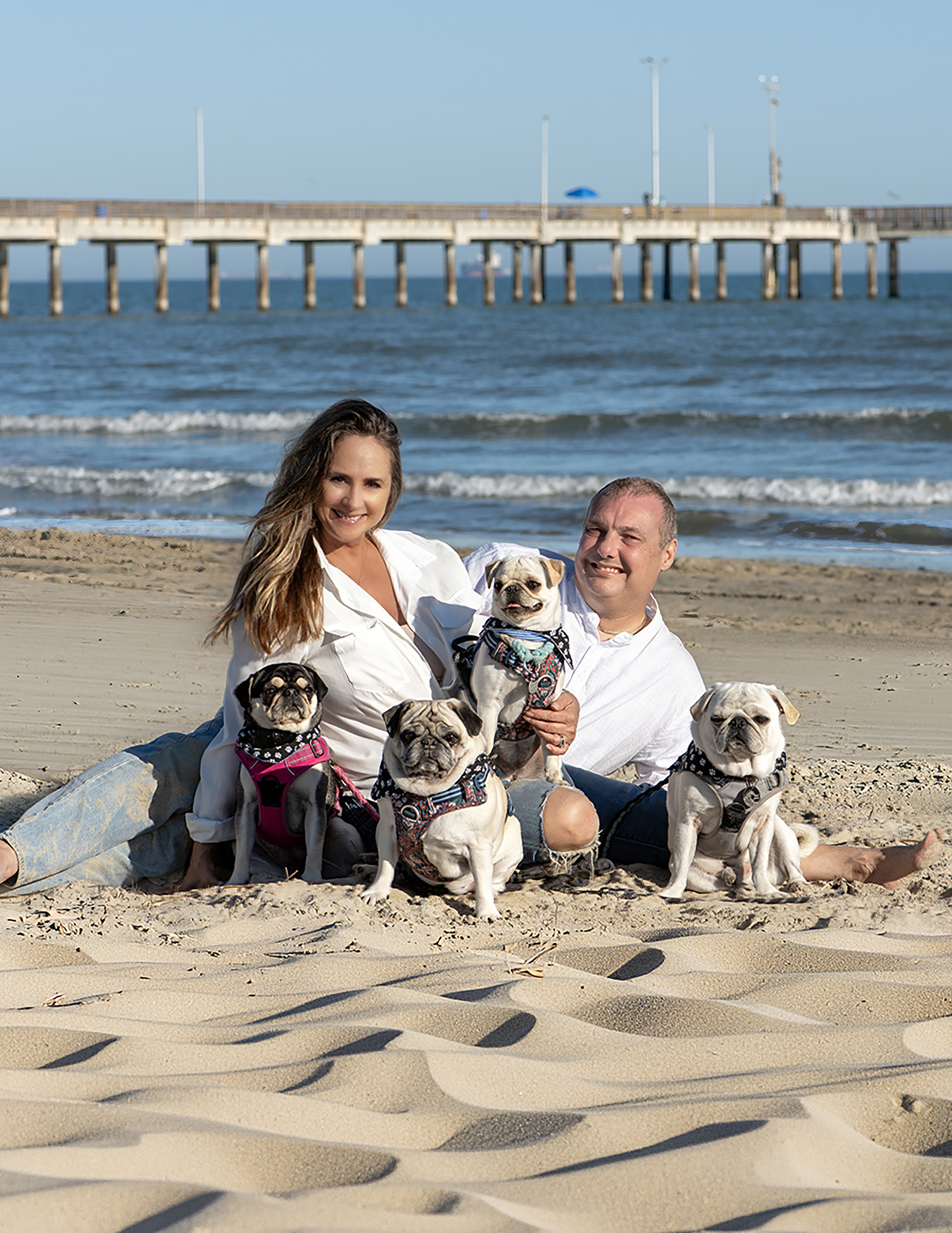 Cute couple on the Port Aransas Beach with their family of four pugs