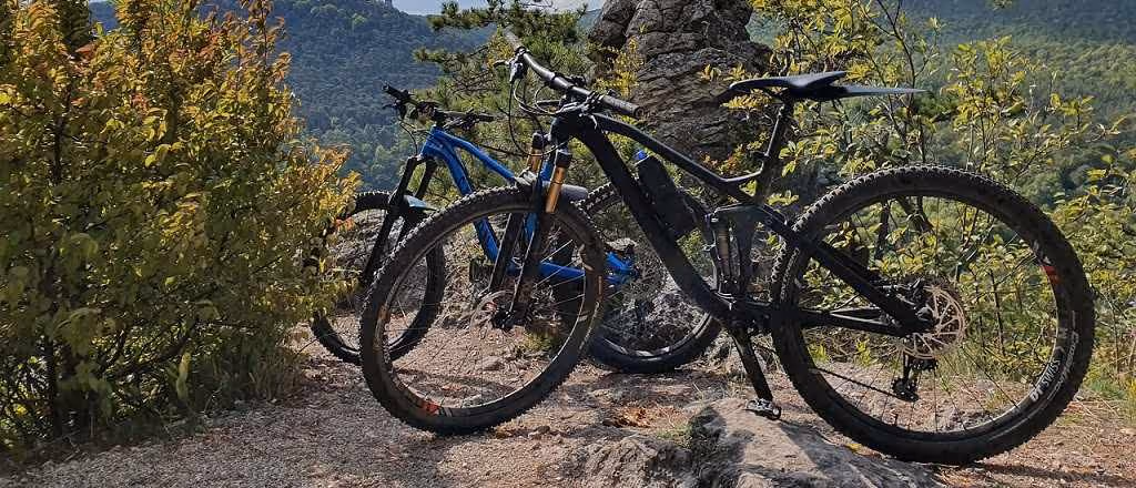 Zwei Mountainbikes auf felsigem Gelände mit bewaldeten Hügeln im Hintergrund. Das Bild steht stellvertretend für unsere Mountainbike-AG.