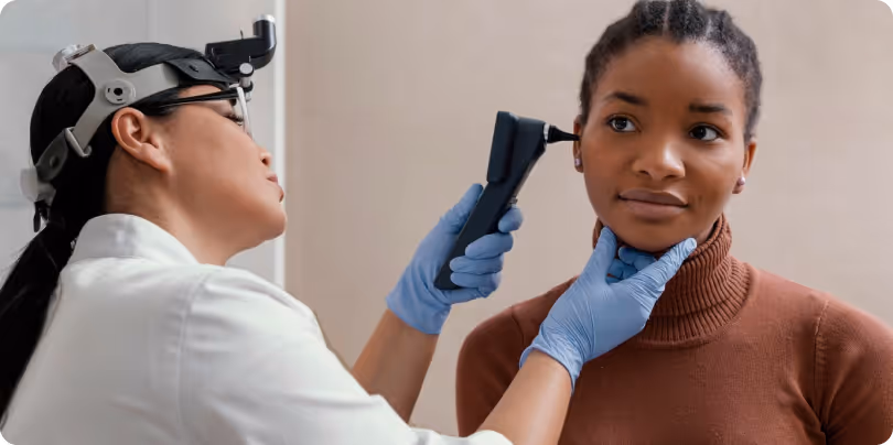 A Audiologist remove earwax from a young lady