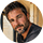 Portrait d'un homme barbu souriant portant une chemise en jean bleu clair.
