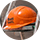 Casque de chantier orange posé sur un support métallique.