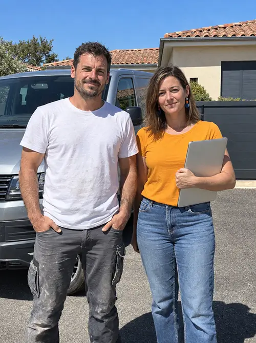 Un artisan Batappli en habit de chantier et sa femme conjointe collaboratrice devant un véhicule utilitaire.