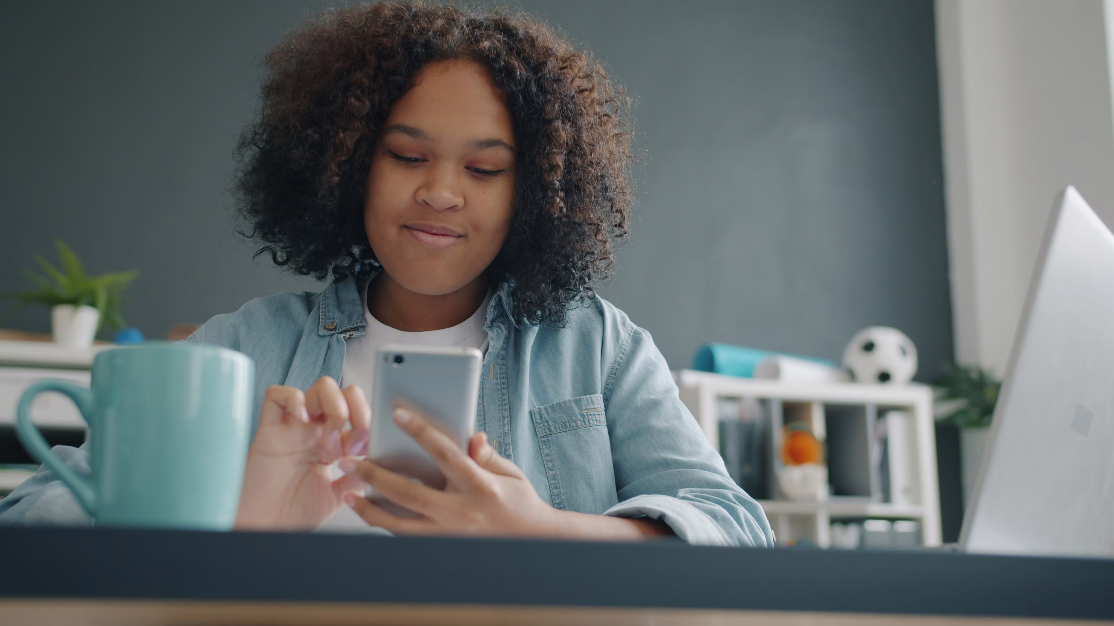 Image d'une jeune étudiante souriante sur son téléphone