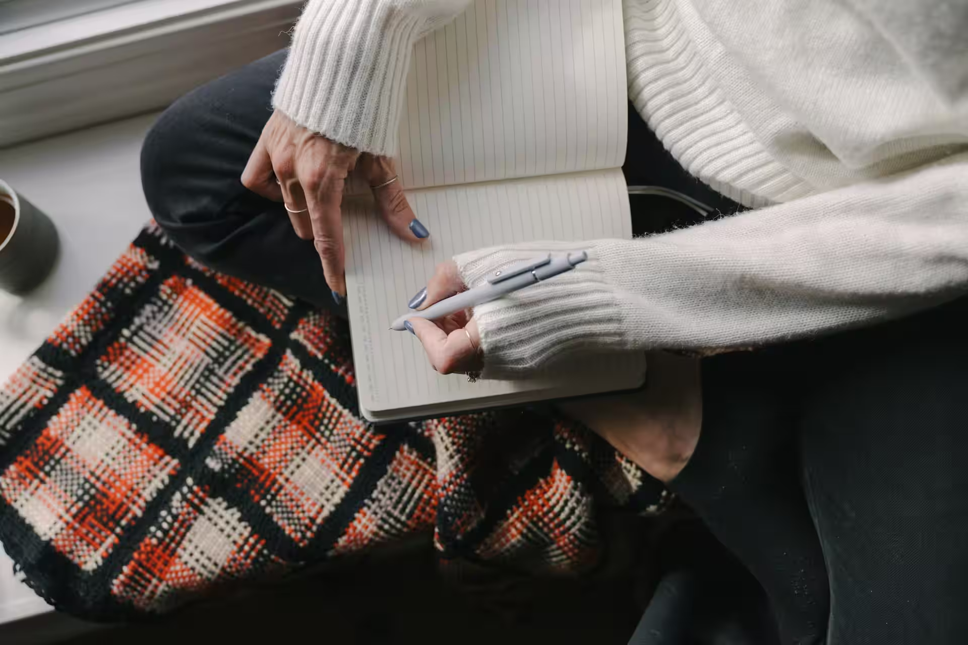 Jeune femme prenant des notes dans un carnet pour construire son projet professionnel