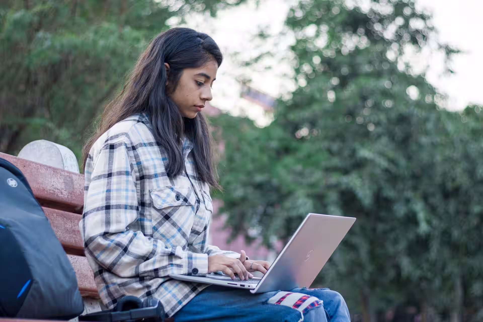 Jeune femme remplissant son tableau de suivi de candidature sur un ordinateur portable